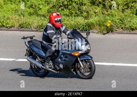 Suzuki GSXF 750 Sport-Tourenmotorrad; Motorradfahrer tragen roten Pelzhelmschutz, zweirädrige Transporte, Motorräder, Fahrzeug, Straßen, Motorräder, Motorradfahrer fahren in Chorley, Großbritannien Stockfoto