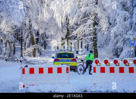 Schmitten, Deutschland. Januar 2021. Ein Radfahrer schiebt sein Fahrrad über die geschlossene deutsche Limes Road. Das Feldberg-Gebiet im Taunus ist wegen Schneebruchs geschlossen und um einen Ansturm von Winterausflüglern zu vermeiden. Der Gipfel ist nur ohne motorisierten Transport zu erreichen. Quelle: Andreas Arnold/dpa/Alamy Live News Stockfoto