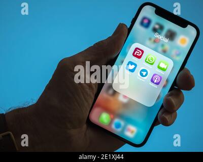 Morgantown, WV - 9. Januar 2021: Männliche Hand mit iPhone und Parler- und Twitter-Apps, um den Streit über das Verbot des Präsident-Trump-Kontos zu illustrieren Stockfoto