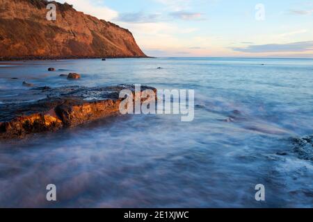 Schnell ankommende Flut in Robin Hood's Bay gleich danach sonnenaufgang mit Blick auf den North Cheeck (auch bekannt als Ness Point) Stockfoto