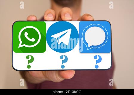 Der nicht erkennbare Mann hält das Telefon mit Whatsapp, Telegram, Signal-Icons auf dem Bildschirm. Stockfoto