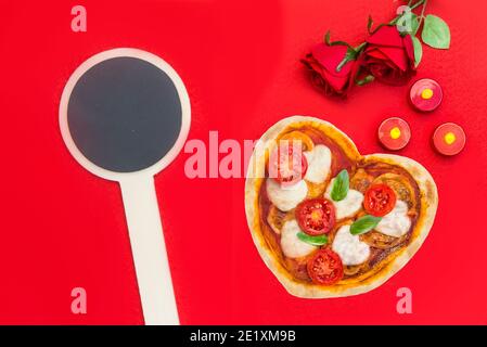 Herzförmige Pizza für einen besonderen Abend Stockfoto