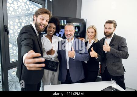 Team von erfolgreichen männlichen und weiblichen multirassischen Geschäftsleute, die Selfie von sich selbst im Büro, feiern Treffen und gemeinsames Projekt. Glücklich Stockfoto