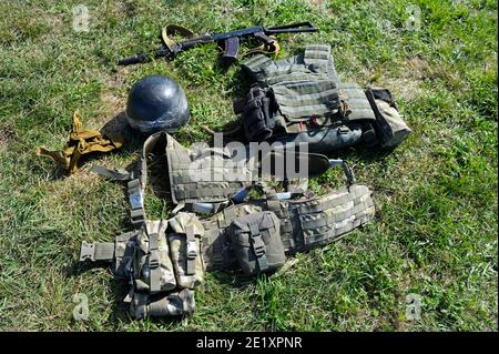 Kalaschnikow Sturmgewehr, Soldatenhelme und Bulletproofs, die auf dem Boden liegen Stockfoto