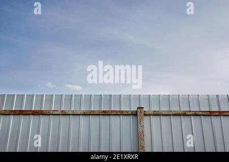 Eiserner rostiger Zaun. Weiße Wellblech oder Zink Textur Oberfläche oder galvanisieren Stahl in der vertikalen Linie Hintergrund. Stockfoto