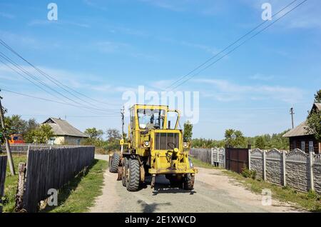 Straßengrader - Schwererde bewegende Straßenbauausrüstung. Industrieller Motorgrader auf dem Boden Stockfoto