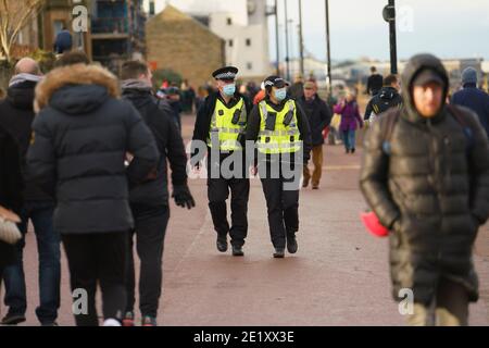 Portobello, Schottland, Großbritannien. 10. Januar 2021. Trotz einer derzeit in Schottland erzwungenen nationalen Sperre waren Portobello Promenade und Strand mit einer großen Anzahl von Menschen beschäftigt, die dort am Sonntagnachmittag waren. Mehrere Polizeipatrouillen waren offensichtlich, dass sie meist unauffällig blieben, aber die Beamten sprachen mit den Kaffeehäffern, um sie zu drängen, die soziale Distanz zwischen den Kunden korrekt zu halten. Iain Masterton/Alamy Live News Stockfoto