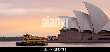 Sonnenaufgang am letzten Tag des Jahres 2020 und das Opernhaus von Sydney. Die Sydney Fähre 'Golden Grove' fährt vor dem Opernhaus vorbei. Stockfoto