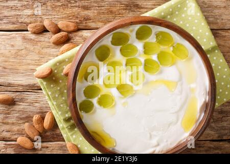 Ajoblanco Spanisch gekühlte weiße Gazpacho Brot und Mandelsuppe in der Nähe in der Platte auf dem Tisch. Horizontale Draufsicht von oben Stockfoto