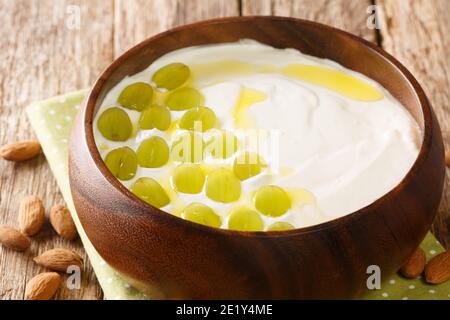 Ajoblanco Spanisch gekühlte weiße Gazpacho Brot und Mandelsuppe in der Nähe in der Platte auf dem Tisch. Horizontal Stockfoto