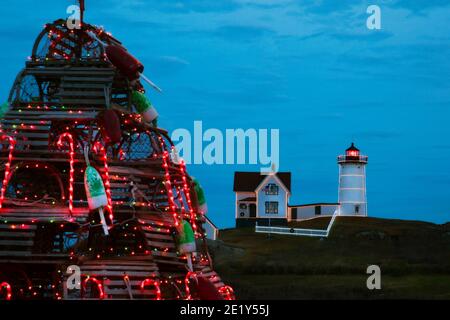 Nubble Leuchtturm ist beleuchtet für den Urlaub in Maine mit traditionellen hölzernen Hummerfalle Urlaubsbaum im Untergrund. Eine Tradition in Neuengland. Stockfoto