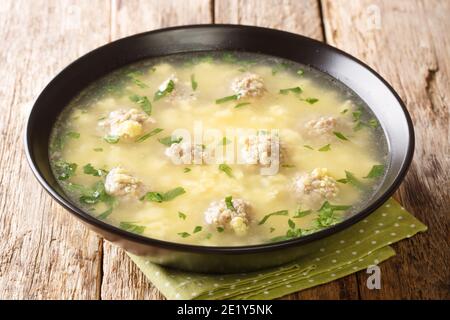 Sciusceddu ist eine festliche italienische Suppe mit den leichtesten, zartesten Fleischbällchen in einer beruhigenden cremigen Eiersuppe in der Nähe auf dem Teller auf dem Tisch. horiz Stockfoto