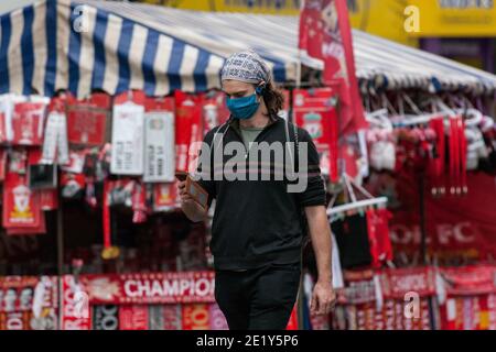 Liverpool, Großbritannien - September 10 2020: Ein Mann mit Gesichtsmaske geht an einem Stand vorbei, der Fußballartikel verkauft, da Liverpool eine Zunahme neuer Coronavirus-Fälle sieht. Stockfoto