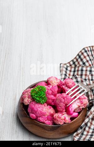 Eingelegter Blumenkohl mit Rote Bete in Holzschale auf weißem Holz Tabelle Stockfoto