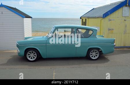 Klassischer blauer Ford Anglia von Strandhütten an der Felixstowe Promenade. Stockfoto