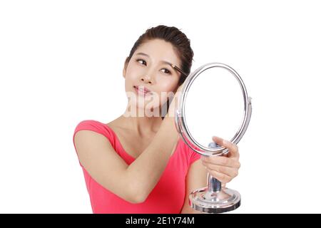 Junge Frau in rosa Kleid mit einem Spiegel, Anwendung Make-up hoch Hochwertige Fotos Stockfoto