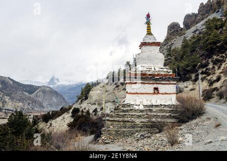 Buddhistische weiße Stupa und schneebedeckten Berggipfel in der Nähe von Braga auf die Annapurna Rundweg, Nepal Stockfoto