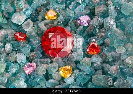 Rubinrote Diamanten sind in einer Enklave von herzförmigen Diamanten auf rohen himmelblauen Edelsteinen platziert. Schmuck in Herzform sind schönes Geschenk für valentinstag Stockfoto