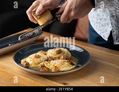 Rabbit Ravioli mit Pilzsauce und seine Raps Parmesan Käse auf dem Tisch im Restaurant, Menü Food-Konzept. Stockfoto