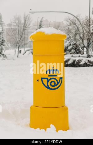 Gelber spanischer Briefkasten mit Schnee bedeckt Stockfoto