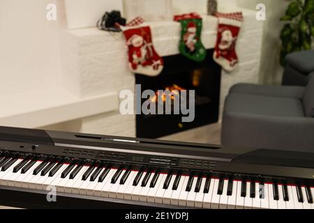 Ein Klavier mit weihnachtsbeleuchtung und Baum Stockfoto