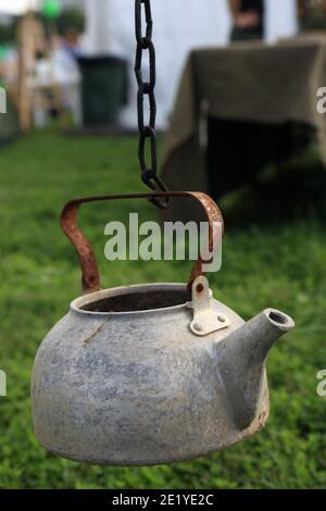 An einer Kette im Park hängt ein alter rostiger Kessel Picknick Stockfoto