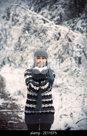 Frau geht im Wald spazieren und genießt den Schnee Stockfoto