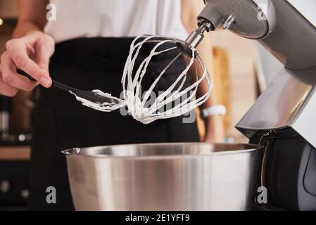 Frau, die Küchenmaschine benutzt, um in der Küche zu kochen Stockfoto
