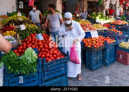 Mardin, Türkei-9. September 2020: Maskierter alter muslim, der während einer Pandemie Obst und Gemüse einkauft. Stockfoto