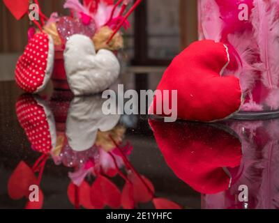 Ein rotes Herz spiegelt sich am Valentinstag im Klavier wider. Stockfoto