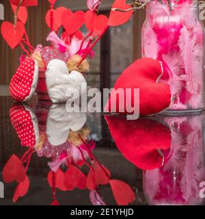 Ein rotes Herz spiegelt sich am Valentinstag im Klavier wider. Stockfoto