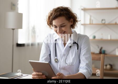 Happy 35s Ärztin mit Software-Anwendung auf digitalen Tablet. Stockfoto