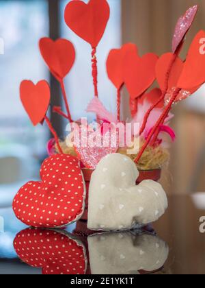 Ein rotes Herz spiegelt sich am Valentinstag im Klavier wider. Stockfoto