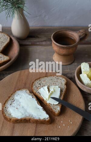 Hausgemachtes Karottenbrot mit Kleie, Butter und Tee in einer Keramikschale. Rustikaler Stil. Vertikale Ausrichtung. Stockfoto