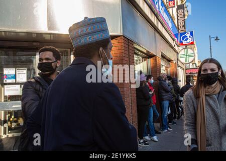 Menschen in schützenden Gesichtsmasken auf Clapham High Street am 9. Januar 2021 in London, England. Stockfoto