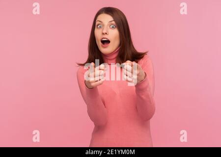 Sie sind etwas Besonderes! Überrascht wunderte sich Frau mit braunen Haaren, die Finger auf die Kamera mit offenem Mund und großen Augen zeigten, schockiert mit der Wahl. Innen Stockfoto