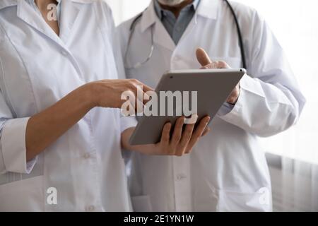 Nahaufnahme von zwei medizinischen Mitarbeitern mit digitalem Computer-Tablet. Stockfoto