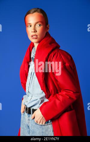 Selbstbewusstes weibliches Modell in baggy Kleidung vor blauem Hintergrund Stockfoto