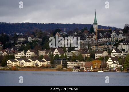 Panoramablick auf das Dorf Zollikon am Ufer des Zürichsees in der Schweiz. Foto vom See im Vordergrund. Stockfoto