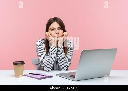 Gelangweilte ineffiziente Frau Büroangestellte am Arbeitsplatz sitzen Kopf auf den Händen gelehnt, einsam enttäuscht Frau müde von Wimp Arbeit. Innenaufnahme im Studio Stockfoto