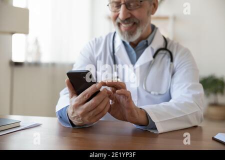 Close up glücklich alt reif männlich Arzt mit Telefon. Stockfoto