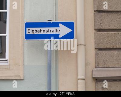 Verkehrsschild mit dem deutschen Text "Einbahnstraße", der übersetzt wird „One Way“ in englischer Sprache Stockfoto