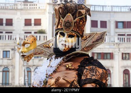 Mann in traditionell dekoriertem Kostüm und bemalter Maske während des Venedig Karnevals in Venedig, Italien Stockfoto