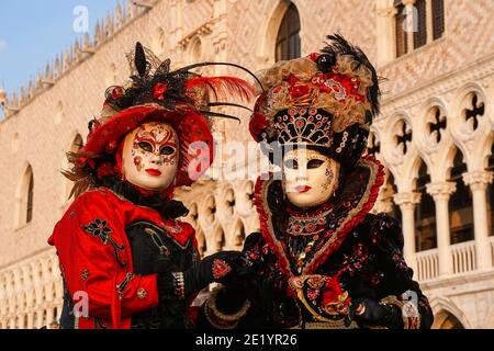 Zwei Frauen in traditionell dekorierten Kostümen und Masken vor dem Dogenpalast während des Karnevals in Venedig, Italien Stockfoto