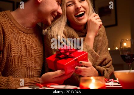 Glückliche junge Frau erhalten Geschenk-Box von liebevollen Mann am Valentinstag. Stockfoto