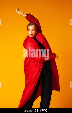 Weibliche Modell in baggy Mantel und Tanz Stockfoto