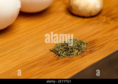 Dill, Eier und Pilze auf einer Schneidefläche bereit für die Vorbereitung. Stockfoto