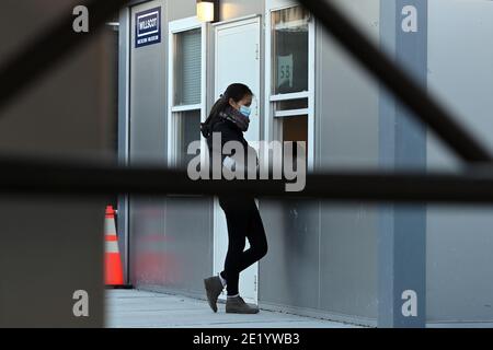 Eine Frau steht an einem Fenster in der Impfstelle des NYCHealth Hospitals, die außerhalb des Brooklyn Army Terminals im Stadtteil Brooklyn in New York City, NY, am 10. Januar 2021 eingerichtet wurde. Am 11. Januar wird New York City fünf vorrangige Impfstellen innerhalb der fünf für die Gruppe 1B aktivieren, zu denen Gesundheitsarbeiter, Bildungsarbeiter, Ersthelfer, Mitarbeiter der öffentlichen Sicherheit, Transitarbeiter und die geschätzten 1.4 Millionen Menschen im Alter von 75 und älter gehören. DIE FLEDERMAUS-Website wird mit 27 Impfpersonal mit dem Ziel ausgestattet sein, jeweils 5 COVID-19 Impfdosen pro Stunde zu verabreichen. (Foto von einem Stockfoto