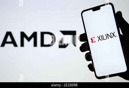 Manchester / Großbritannien - 21. Oktober 2020: AMD übernimmt Xilinx, Concept. XILINX Logo auf der Silhouette des Smartphones in einer Hand und verschwommen gesehen Stockfoto