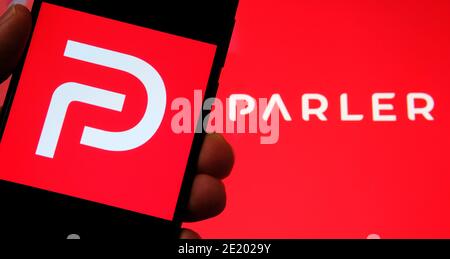 Parler App-Logo auf dem Bildschirm des Smartphones und auf dem verschwommenen Hintergrund zu sehen. Parler ist eine neue Social-Media-Plattform zur Förderung der Meinungsfreiheit. Stockfoto